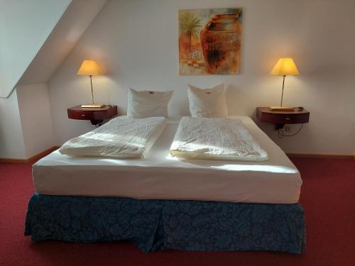 弗赖辛鲁汶小酒馆酒店的配有2盏灯的酒店客房的2张床
