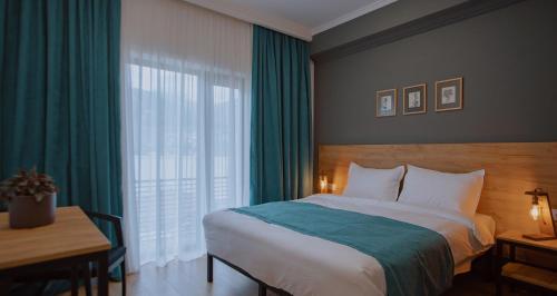 卡兹贝吉Northgate Hotel Kazbegi的一间卧室配有一张床、一张书桌和一个窗户。