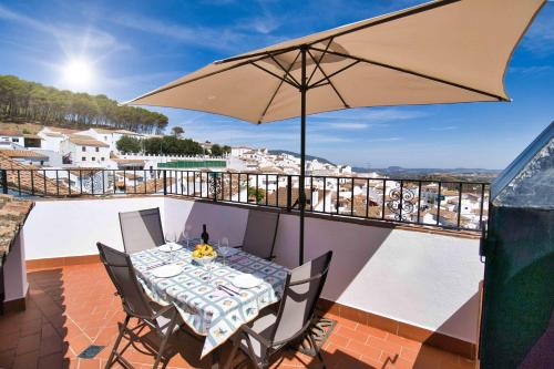 埃尔加斯托尔马德罗内拉度假屋的阳台配有桌椅和遮阳伞