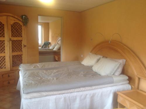 HishultLanthotellet Hishult的一间卧室配有一张带白色床单和镜子的床