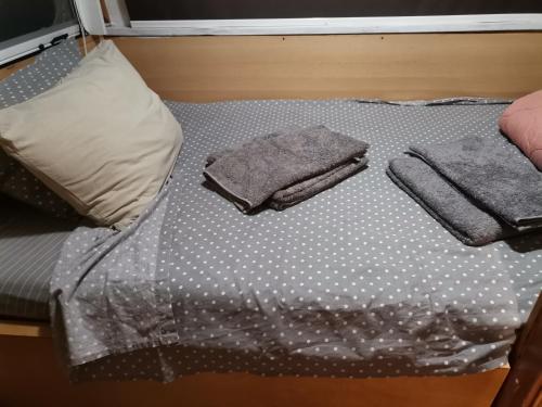 扎金索斯镇Green Garden Caravan的床上配有波尔卡圆点床单和毛巾。