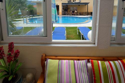 罗达Eleni Apartments的透过2扇窗户可欣赏到游泳池的景色