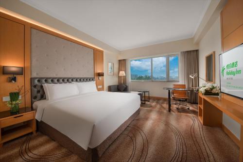 北京北京长峰假日酒店的酒店客房设有一张大床和一张书桌。