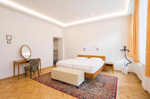 利托米什尔Luxusní velký apartmán s terasou v centru Litomyšle的一间卧室配有一张床、一张书桌和一面镜子