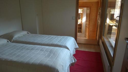 普马拉Kuoreksenniemi Villas & Lakehouse的两张位于一个房间的床,门通往门廊