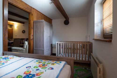 特尔乔夫Chalupa Juraj Terchová的一间带婴儿床的卧室和一间带用餐室的房间