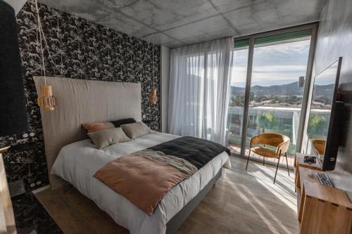 阿雅克修VILLA ALBA ROSULA的一间卧室设有一张大床和一个大窗户