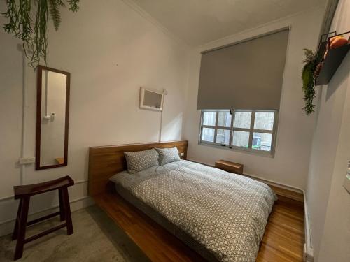 宜兰市神农青舍的一间卧室设有一张床和一个窗口