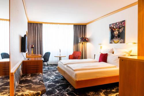 沃尔姆斯多姆酒店的酒店客房设有一张大床和一张书桌。