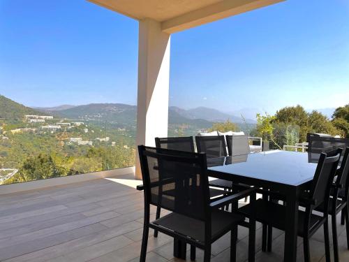 阿雅克修villa I Cresti proche centre ville et plages的阳台的用餐室配有桌椅