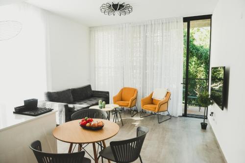 特拉维夫AirTLV - Rambam Residence W Private MAMAD!的客厅配有沙发、椅子和桌子