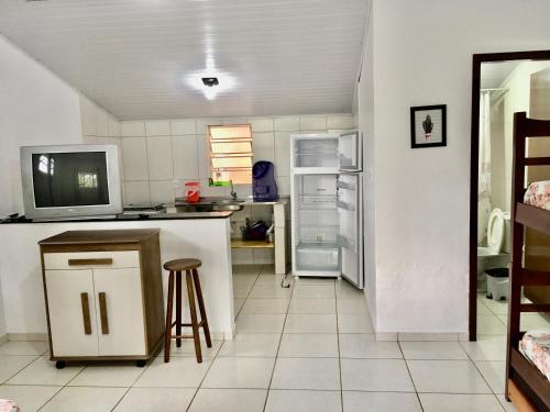 乌巴图巴Chalés Damata的厨房配有冰箱、桌子和凳子