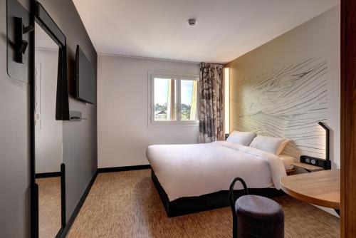 PublierB&B HOTEL Evian Publier的酒店客房设有一张大床和一张桌子。
