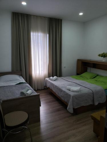 梅斯蒂亚Guest House Nanu的酒店客房设有两张床和窗户。