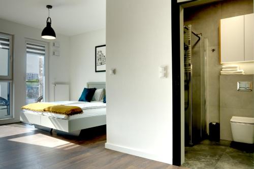 波兹南Essence Apartments Amber的一间卧室设有一张床和一间浴室。