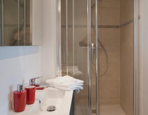 滑铁卢Wellintown Guest House的浴室设有水槽和带红杯的淋浴