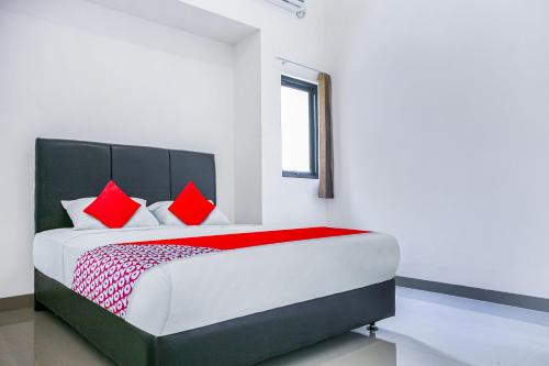 KebintiOYO 3438 Pasir Padi Inn Syariah的一间卧室配有一张带红色枕头的大床
