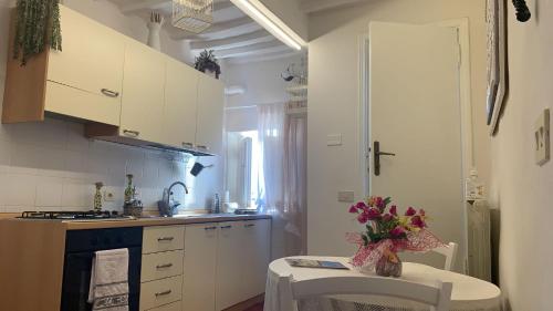 阿雷佐Appartamento incantevole nel centro di Arezzo的厨房,桌子上放着花瓶