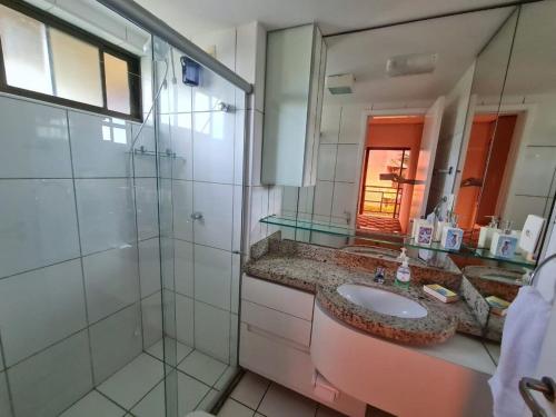 普赖尼亚Apartamento mobiliado Beach Place Porto das Dunas的一间带水槽、淋浴和镜子的浴室