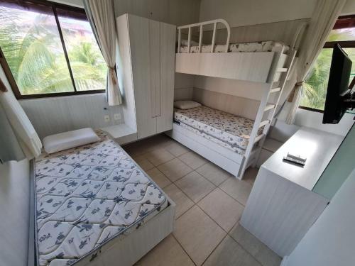普赖尼亚Apartamento mobiliado Beach Place Porto das Dunas的一间卧室配有两张双层床和一张书桌