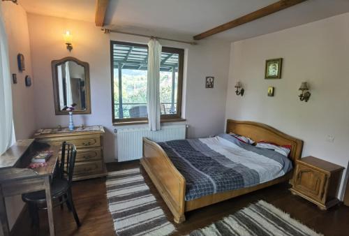 科尔贝尼vila zia的一间卧室配有一张床、一张书桌和一面镜子