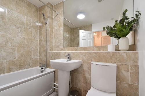 卡特顿Stylish One Bed Apartment Near Cotswolds RAF的一间带水槽、卫生间和镜子的浴室