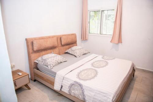 Mtsamgamoujiguest mtsangamouji F3的一间卧室配有一张带白色床单的床和一扇窗户。