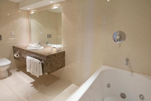 北帕默斯顿帕默斯顿北国敦酒店的带浴缸、盥洗盆和卫生间的浴室