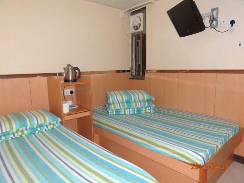 香港富华宾馆的一间卧室设有两张床,墙上配有电视。