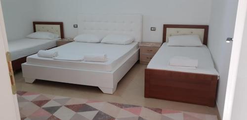 迪夫亚卡Guesthouse Anila的一间卧室设有两张床和两个床头柜