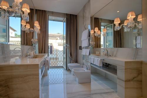 罗马Palazzo Nainer的一间带两个盥洗盆、卫生间和镜子的浴室