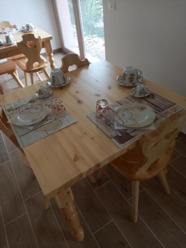 CollebrincioniUn Passo Dal Cielo的一张木桌,上面有盘子和盘子