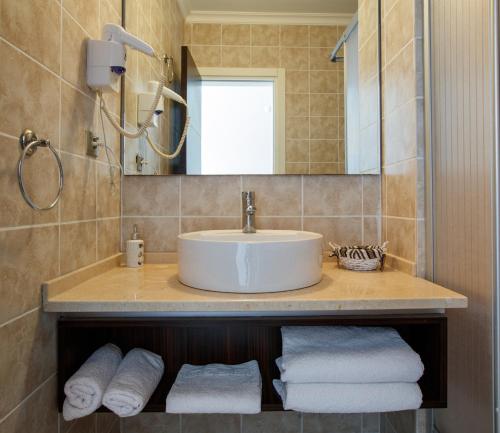 切什梅Suena hotel Çeşme的浴室配有盥洗盆、镜子和毛巾