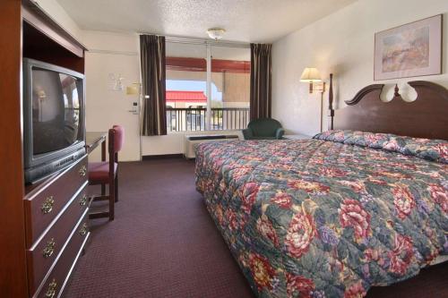 俄克拉何马城俄克拉何马展览会场速8酒店的配有一张床和一台平面电视的酒店客房