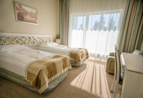 纳尔瓦约埃苏Noorus SPA Hotel的酒店客房设有两张床和窗户。