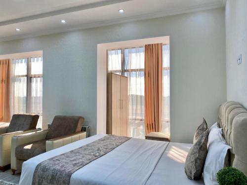 TürkistanComfort Hotel的一间卧室配有一张床、一张沙发和窗户。