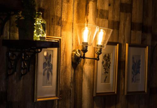 纳尔斯伯勒Bay Horse Inn Goldsborough的墙上有几盏灯,上面有照片