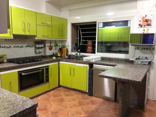 丹吉尔Apartment Nazaha for families only的厨房配有石灰绿色橱柜和花岗岩台面