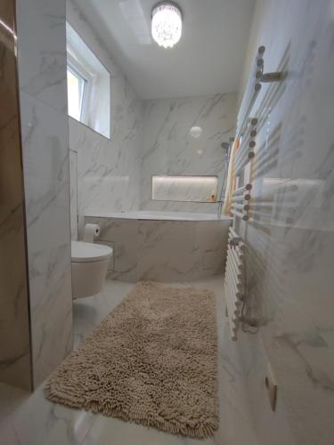 Heľpa卢卡斯旅馆的白色浴室,地板上铺有地毯