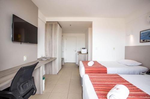 马卡埃Flat 905 - Localização privilegiada em Macaé的酒店客房设有两张床和一台平面电视。