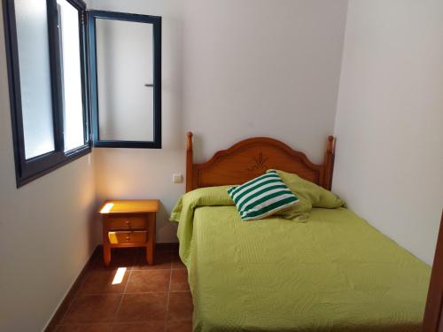 法马拉Casa la Caleta的一间卧室设有一张绿色的床和一个窗户。