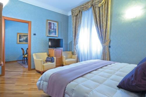 罗马潘菲利艾尔格林公园酒店的一间卧室配有一张床,另一间配有电视。