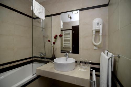 波罗维茨冰天使酒店的浴室配有水槽、淋浴和浴缸。