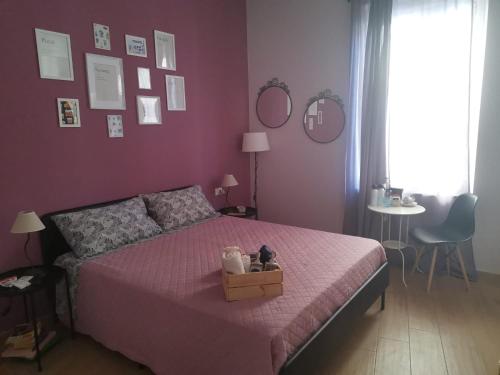 米兰B&B Casa Caterina的一间卧室配有粉红色的床,上面有盒子