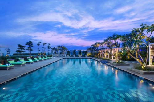当格浪坦格朗诺富特酒店的一个带椅子和棕榈树的大型游泳池