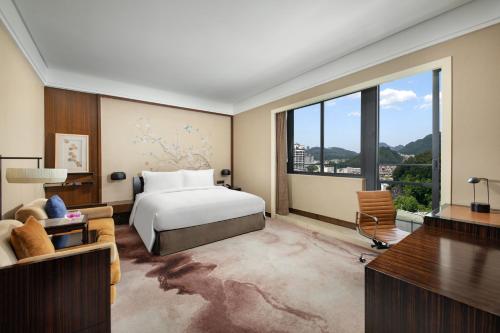 黄山市黄山昱城皇冠假日酒店的一间卧室设有一张床和一个大窗户