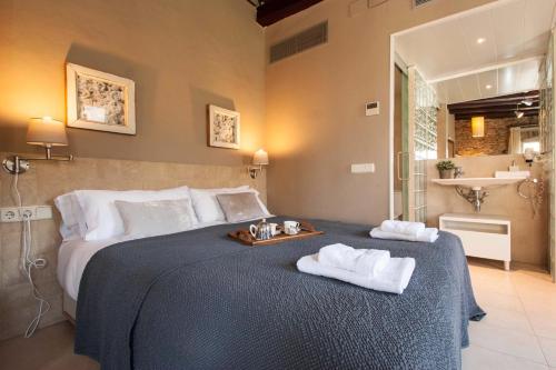 巴塞罗那Decô Apartments Barcelona-Born St.的一间卧室配有一张大床和毛巾