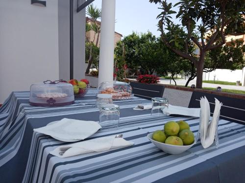 普拉亚·阿马勒B&B Villa dei Desideri的一张带一碗水果的蓝白桌子