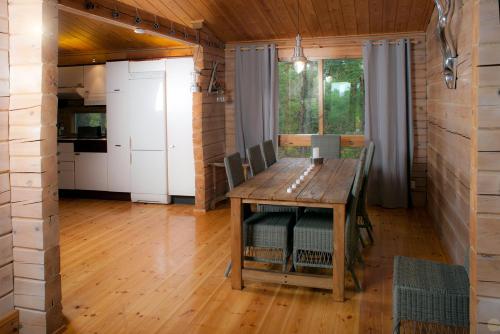 TaalintehdasVilla Bergholmen的一间带木桌的用餐室和一间厨房