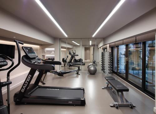 雅典Heritage Hill Hotel的健身房设有两个跑步机和两个椭圆机
